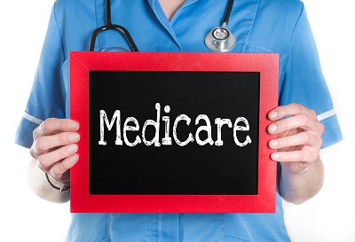 Medicare- Physician with chalkboard on isolated white background