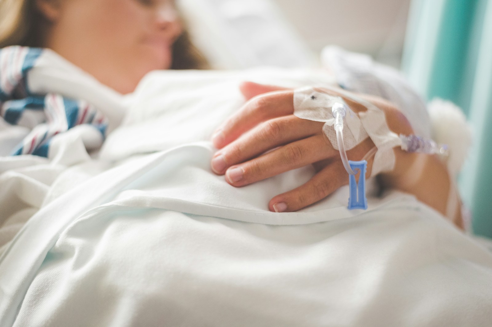a woman laying in a hospital bed with an iv in her hand, medicare