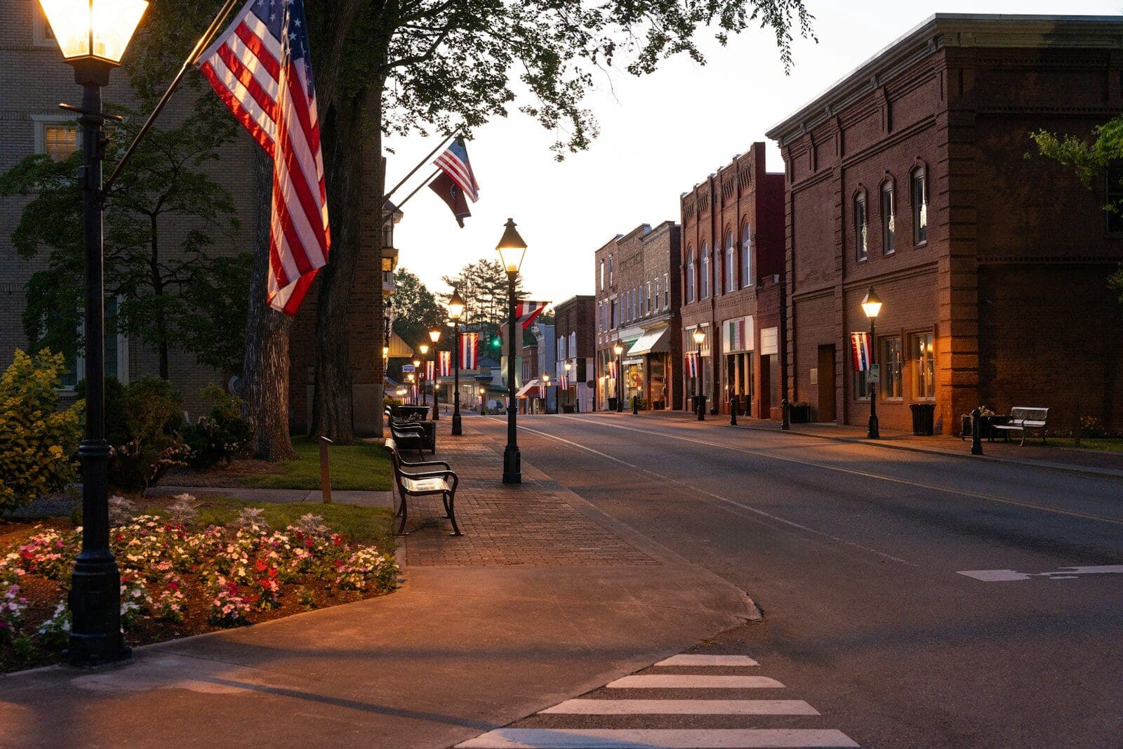 Small town street at dusk with american flags